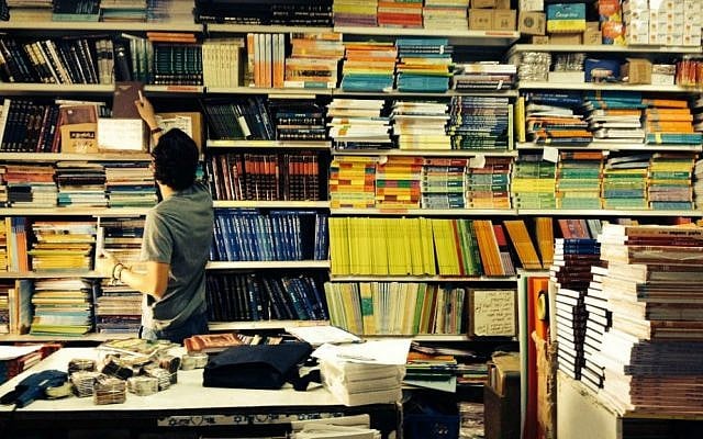 Illustrative image of a boy searching for books in Jerusalem's Intercol school supply store (Jessica Steinberg/Times of Israel)