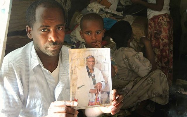 Simegnew Yosef Naga, 34, holds up a photo of his grandmother, who lives in Ramle, in his home in Gondar on April 15, 2016. (Melanie Lidman/Times of Israel)