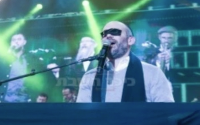 Yonatan Razel, with masking tape over his eyes, at a Jerusalem concert for women on December 3, 2017 (Hadashot news screenshot)