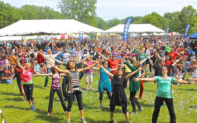 At the Greater Chicago Jewish Festival, "flash mob" dancers perform an Israeli folk dance medley as part of the biennial outdoor event, which included music stages, art and craft fair, kosher food, children's activities and was attended by over 20,000 people during the day, in Morton Grove, IL, on June 8, 2014. (iStock)