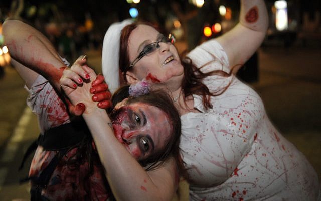 A young woman sinks her teeth into celebrating Purim (photo credit: Gili Yaari/Flash 90)