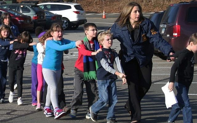 In this photo provided by the Newtown Bee, Connecticut State Police lead a line of children from the Sandy Hook Elementary School in Newtown, Conn. on Friday, Dec. 14, 2012 after a shooting at the school. (photo credit: AP Photo/Newtown Bee, Shannon Hicks) In this photo provided by the Newtown Bee, Connecticut State Police lead a line of children from the Sandy Hook Elementary School in Newtown, Conn. on Friday, Dec. 14, 2012 after a shooting at the school. (photo credit: AP Photo/Newtown Bee, Shannon Hicks)