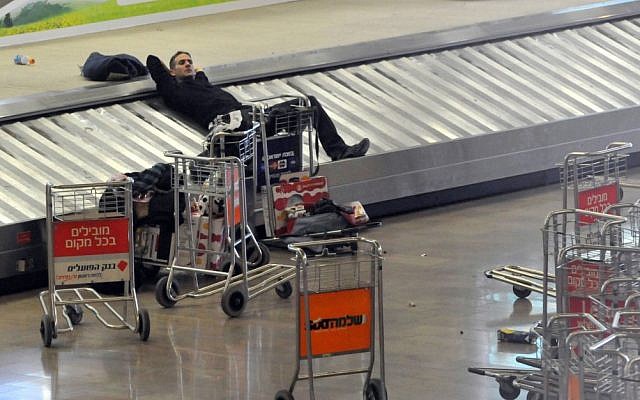 A traveler rests on the luggage belt at Ben Gurion International Airport during a strike in 2010 (photo credit: Yossi Zeliger/Flash90) A traveler rests on the luggage belt at Ben Gurion International Airport during a strike in 2010 (photo credit: Yossi Zeliger/Flash90)