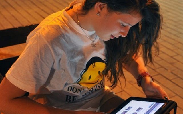 A girl using a tablet in Jerusalem. (Illustrative photo credit: Serge Attal/Flash90)