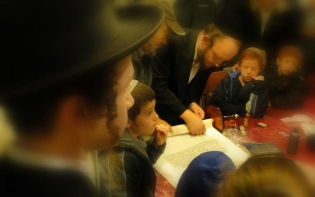 Many different kippahs and hats around the Torah