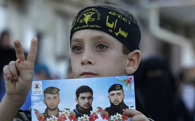 A young supporter of Islamic Jihad holds a picture of group members killed in clashes with Israeli forces, during a rally marking the 13th anniversary of the Second Intifada, in the Jabaliya Refugee Camp, northern Gaza Strip, on Thursday (photo credit: AP/Adel Hana) A young supporter of Islamic Jihad holds a picture of group members killed in clashes with Israeli forces, during a rally marking the 13th anniversary of the Second Intifada, in the Jabaliya Refugee Camp, northern Gaza Strip, on Thursday (photo credit: AP/Adel Hana)