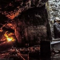 Worshiper at the underground tomb of Mishnaic-era scholar, R' Yehuda Bar Ilai, near Safed.

To the left is an engraved plaque signifying the site where remains of Jews slaughtered in the Holocaust were interred by survivors in the Israel, in a public ceremony in 1949. Click on photo for full size image in new window.