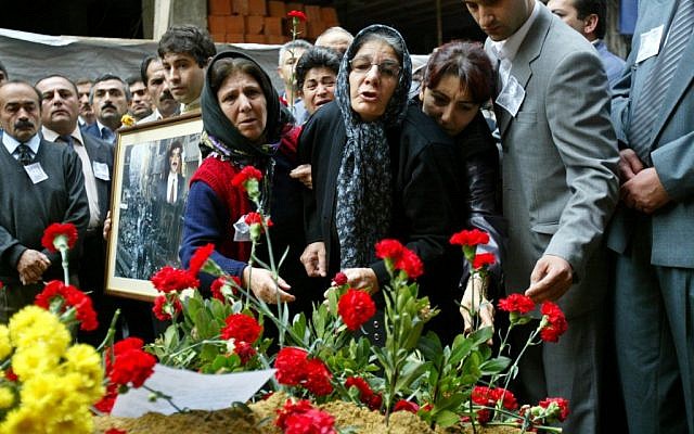 Nermin Sahin, center, whose son Murat was killed following a suicide attack at an Istanbul synagogue, lays flowers at the scene of the blast in Istanbul, November 15, 2004 [photo credit: Osman Orsal/AP]