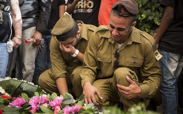 Fellow soldiers seen mourning over the fresh grave of Golani soldier, Moshe Malko, at the Har Herzl Military Cemetery in Jerusalem, on July 21, 2014. Staff Sgt. Moshe Malko, 20, from Jerusalem, was killed July 20 before dawn during combat in the Gaza Strip. (photo credit: Hadas Parush/Flash90)