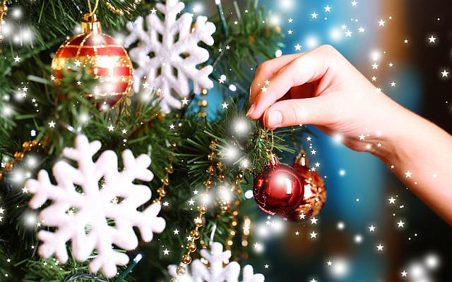 Illustrative. Decorating a Christmas tree. (Shutterstock)