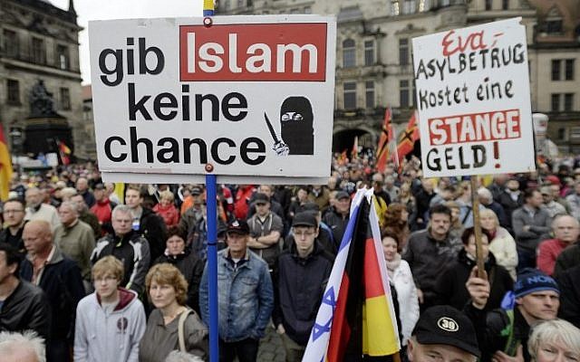 Supporters of the German right-wing movement PEGIDA (Patriotic Europeans Against the Islamisation of the Occident) hold up a poster reading "Give No Chance to Islam" as they attend a PEGIDA rally on June 1, 2015 in Dresden, eastern Germany (Jens Schlueter/AFP)