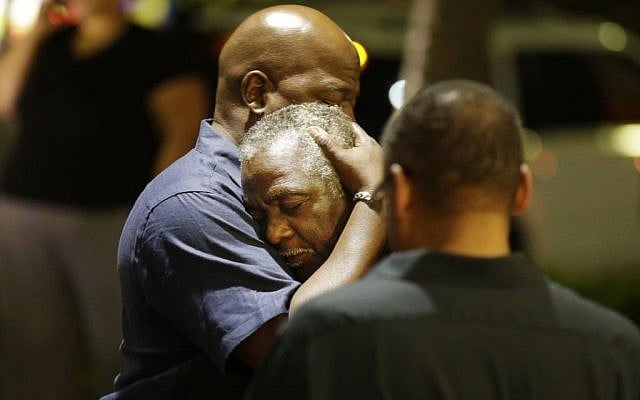 Worshippers embrace following a group prayer across the street from the scene of a shooting on June 17, 2015, in Charleston, South Carolina. (David Goldman/AP) Worshippers embrace following a group prayer across the street from the scene of a shooting on June 17, 2015, in Charleston, South Carolina. (David Goldman/AP)