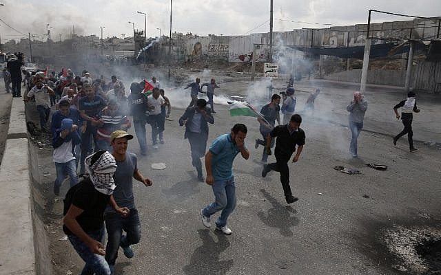 File. Palestinians run from tear gas smoke during clashes with Israeli security forces at the Qalandia checkpoint between Jerusalem and Ramallah in the West Bank, on October 6, 2015. (AFP PHOTO/ABBAS MOMANI) File. Palestinians run from tear gas smoke during clashes with Israeli security forces at the Qalandia checkpoint between Jerusalem and Ramallah in the West Bank, on October 6, 2015. (AFP PHOTO/ABBAS MOMANI)