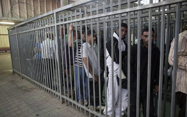Palestinian workers wait to cross the checkpoint from the West Bank town of Ramallah to work in Israel on June 4, 2013. Photo by Yonatan Sindel/Flash90