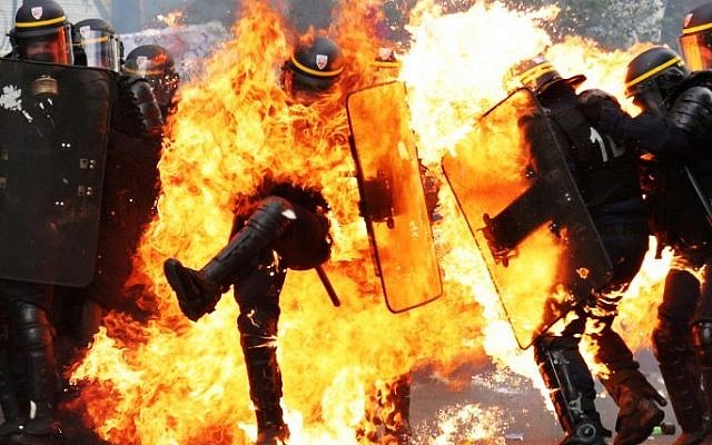 French CRS anti-riot police officers are engulfed in flames as they face protesters during a march for the annual May Day workers' rally in Paris on May 1, 2017. (AFP PHOTO / Zakaria ABDELKAFI) French CRS anti-riot police officers are engulfed in flames as they face protesters during a march for the annual May Day workers' rally in Paris on May 1, 2017. (AFP PHOTO / Zakaria ABDELKAFI)