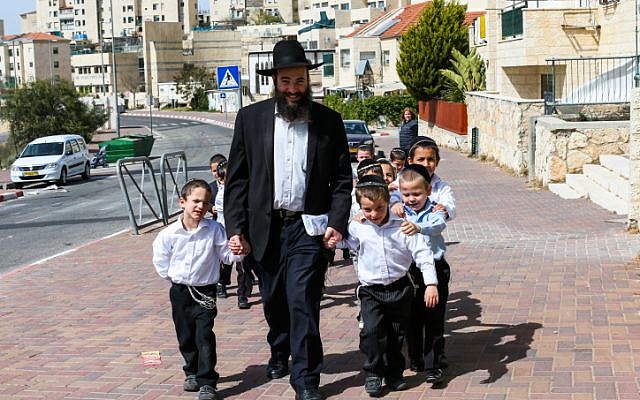 Illustrative: An ultra-Orthodox teacher takes the kids from his class to a walk in the sun on March 12, 2013, in the West Bank settlement of Beitar Ilit. (Nati Shohat/Flash90/File)