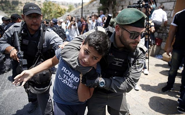 Illustrative: Israeli border guards detain a Palestinian youth during a demonstration outside the Lions Gate in Jerusalem's Old City on July 17, 2017. (AFP/ AHMAD GHARABLI)