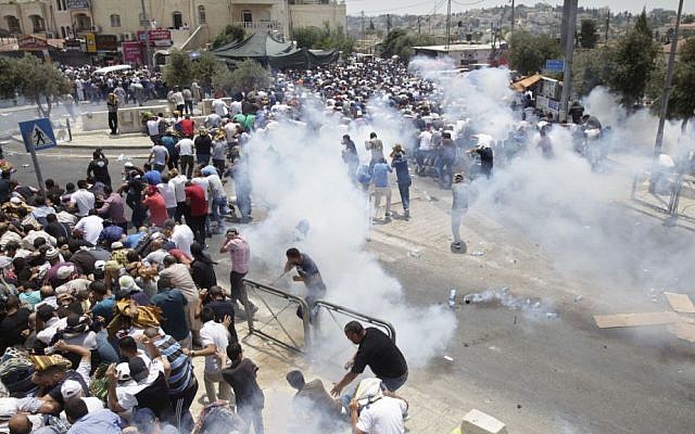 Palestinians run away from tear gas thrown by police officers outside Jerusalem's Old City, Friday, July 21, 2017. (AP Photo/Mahmoud Illean) Palestinians run away from tear gas thrown by police officers outside Jerusalem's Old City, Friday, July 21, 2017. (AP Photo/Mahmoud Illean)