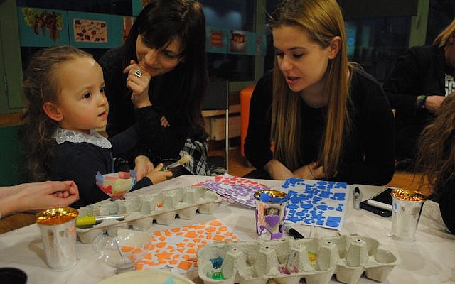 Sara Zielinski, with her mother Elizabeth, center, and a volunteer at a pre-Shabbat program at the Jewish Community Center of Krakow. Sara is part of the inaugural class of Frajda, the first pluralistic Jewish nursery and preschool in Krakow since World War II. (Courtesy of Jewish Community Center of Krakow/via JTA) Sara Zielinski, with her mother Elizabeth, center, and a volunteer at a pre-Shabbat program at the Jewish Community Center of Krakow. Sara is part of the inaugural class of Frajda, the first pluralistic Jewish nursery and preschool in Krakow since World War II. (Courtesy of Jewish Community Center of Krakow/via JTA)