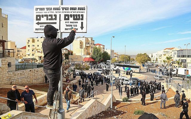 Police stand guard as Beit Shemesh municipal workers take down "modesty" signs in the city on December 11, 2017. (Yaakov Lederman/Flash90) Police stand guard as Beit Shemesh municipal workers take down "modesty" signs in the city on December 11, 2017. (Yaakov Lederman/Flash90)