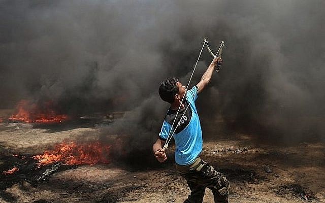 A Palestinian man uses a slingshot during clashes with Israeli forces along the border with the Gaza strip east of Khan Younis on May 14, 2018 (AFP PHOTO / SAID KHATIB)