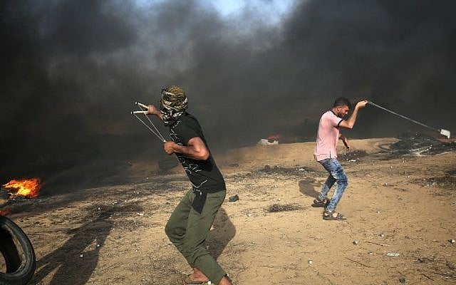 Palestinian demonstrators use slingshots to hurl rocks at Israeli forces during clashes along the border with the Gaza Strip east of Khan Younis on May 18, 2018. (AFP Photo/Said Khatib) Palestinian demonstrators use slingshots to hurl rocks at Israeli forces during clashes along the border with the Gaza Strip east of Khan Younis on May 18, 2018. (AFP Photo/Said Khatib)