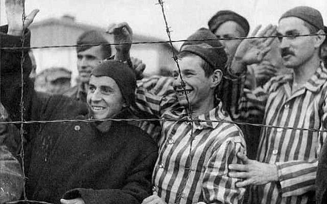 Illustrative. Survivors in Dachau greet their American liberators. (Source: USHMM)