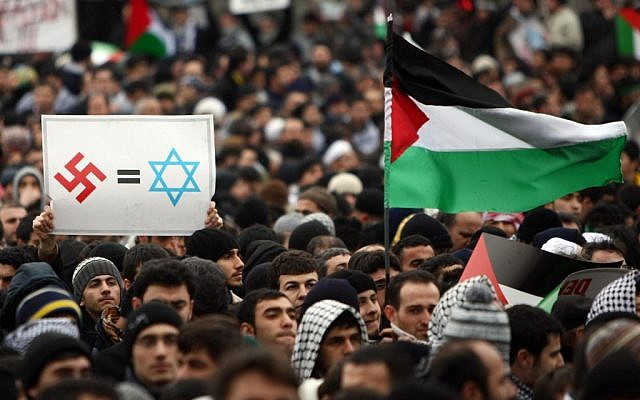 A Turkish demonstrator holding a banner with a Nazi swastika and Star of David in Istanbul, Jan. 2, 2009. (Mustafa Ozer/AFP/Getty Images)