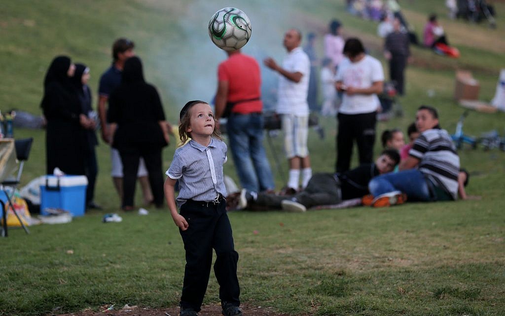 A Young ultra orthodox jewish boy plays football  in Sacher Park in the center of Jerusalem. August 14, 2012. (Nati Shohat/FLASH90)