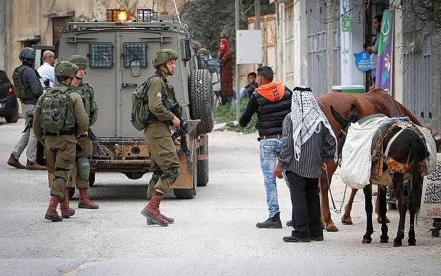 IDF soldiers search for Abed al-Karim Assi, suspected of stabbing an Israeli man to death, in the village of Kifl Haris in the northern West Bank, February 5, 2018. (Nasser Ishtayeh/Flash90)