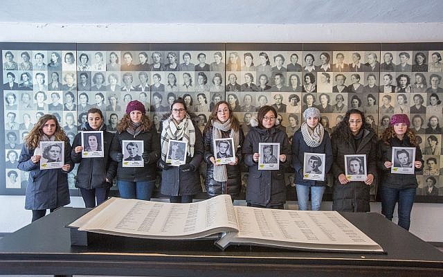 TRTN Fellows hold photographs of Holocaust victims at the Ravensbruck Concentration Camp in Germany.