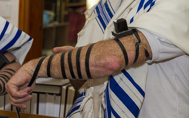 Illustrative: An adult man putting Tefillin on his arm (iStock) Illustrative: An adult man putting Tefillin on his arm (iStock)
