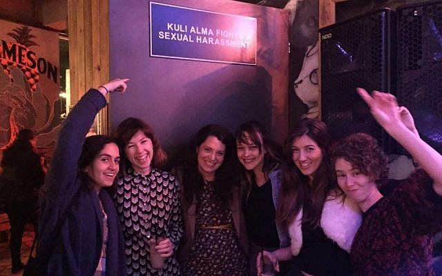 'Layla Tov' activists under a sign at the Kuli Alma Bar signaling a no tolerance policy for sexual harassment (Courtesy of 'Layla Tov').