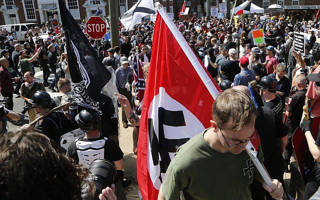 This Saturday, Aug. 12, 2017 image shows s white supremacist carrying a NAZI flag into the entrance to Emancipation Park in Charlottesville, Va. (AP Photo/Steve Helber) This Saturday, Aug. 12, 2017 image shows s white supremacist carrying a NAZI flag into the entrance to Emancipation Park in Charlottesville, Va. (AP Photo/Steve Helber)