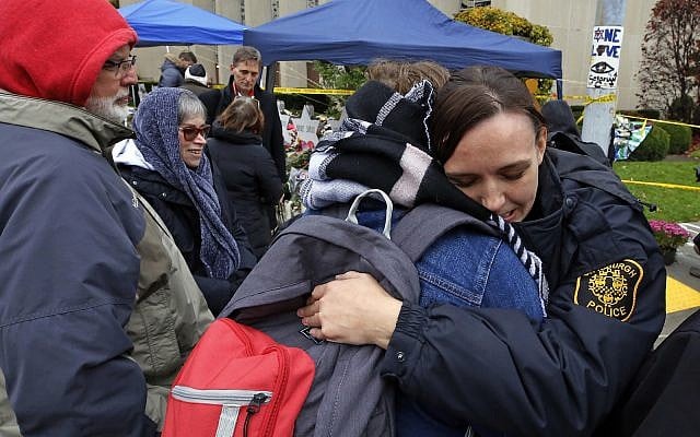 Pittsburgh Police officer Sarah Pratt gets a hug before a Shabbat morning worship service held outside the Tree of Life Synagogue Saturday, Nov. 3, 2018 in Pittsburgh. (AP Photo/Gene J. Puskar)