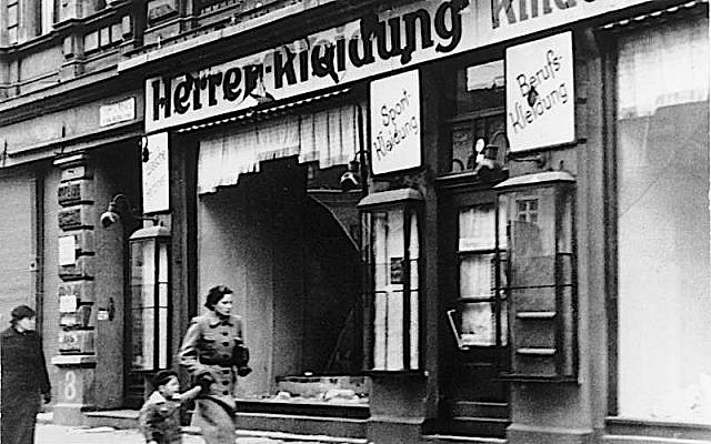 Woman and child passing smashed shop windows after Kristallnacht in Magdeburg, Germany, November 1938. (Bundesarchiv/Friedrich, H./CC-BY-SA 3.0)