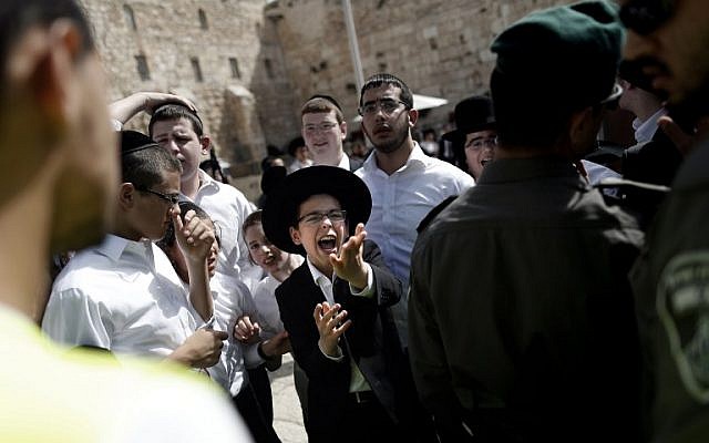 Illustrative: A group of Jewish ultra-Orthodox men and boys oppose the prayer service of the Women of the Wall, April 24, 2016. (AFP Photo/Thoman Coex)