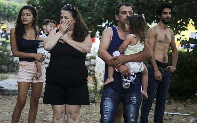 Illustrative: Residents look on in shock after a rocket hit a house in coastal Ashkelon early on the morning of August 26, 2014. The family living in the house were not injured -- they were on the way to the bomb shelter when the rocket hit. Passersby were hurt by broken glass, while many others suffered from shock. (Edi Israel/Flash90) Illustrative: Residents look on in shock after a rocket hit a house in coastal Ashkelon early on the morning of August 26, 2014. The family living in the house were not injured -- they were on the way to the bomb shelter when the rocket hit. Passersby were hurt by broken glass, while many others suffered from shock. (Edi Israel/Flash90)