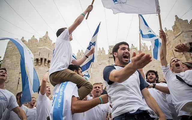 Jewish revelers wave Israeli flags as they celebrate Jerusalem Day by dancing through Damascus Gate on their way to the Western Wall. May 13, 2018. (Yonatan Sindel/Flash90)