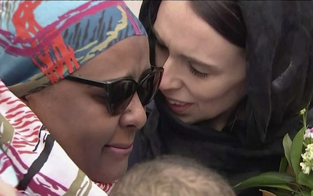 New Zealand's Prime Minister Jacinda Ardern, right, consoles a woman as she visited Kilbirnie Mosque to lay flowers among tributes to Christchurch attack victims, in Wellington, Sunday, March 17, 2019. (from video - TVNZ via AP)