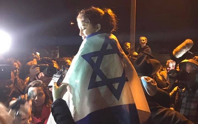 Noya Dahan sits atop her father's shoulders draped in the Israeli flag. Photo- Aaron Raimi