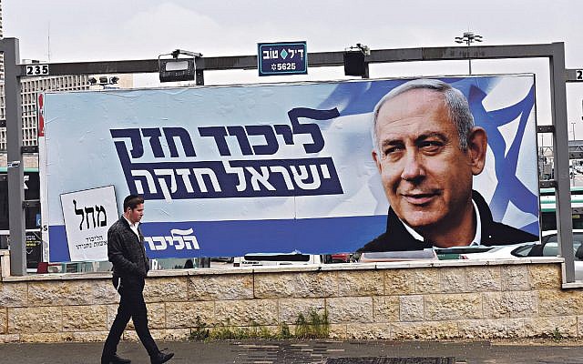 A man walks past an election campaign poster for Israeli Prime Minister Benjamin Netanyahu in Jerusalem, April 1, 2019. (Debbie Hill/UPI)