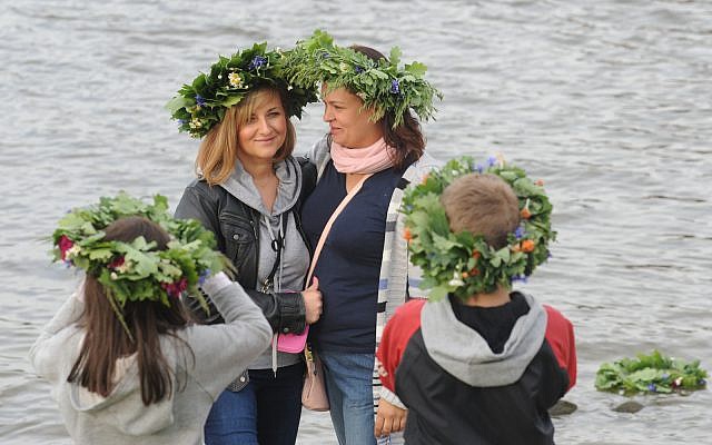 Women with traditional wreaths on their heads take photos during midsummer celebrations on the banks of the Vistula river in Warsaw, Poland, Saturday, June 21, 2014. (AP Photo/Alik Keplicz) Women with traditional wreaths on their heads take photos during midsummer celebrations on the banks of the Vistula river in Warsaw, Poland, Saturday, June 21, 2014. (AP Photo/Alik Keplicz)