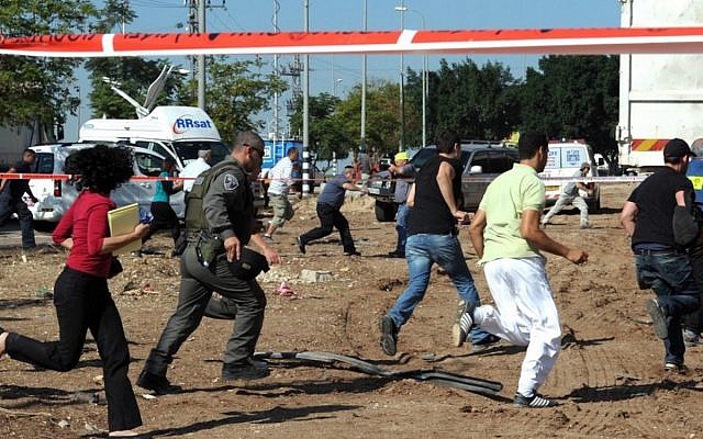 Israelis run for cover as a warning siren sounds for incoming rockets in the southern Israeli city of Kiryat Malachi, where three Israelis were killed by a rocket attack on Thursday (Photo credit: Moshe Milner/GPO/Flash90)