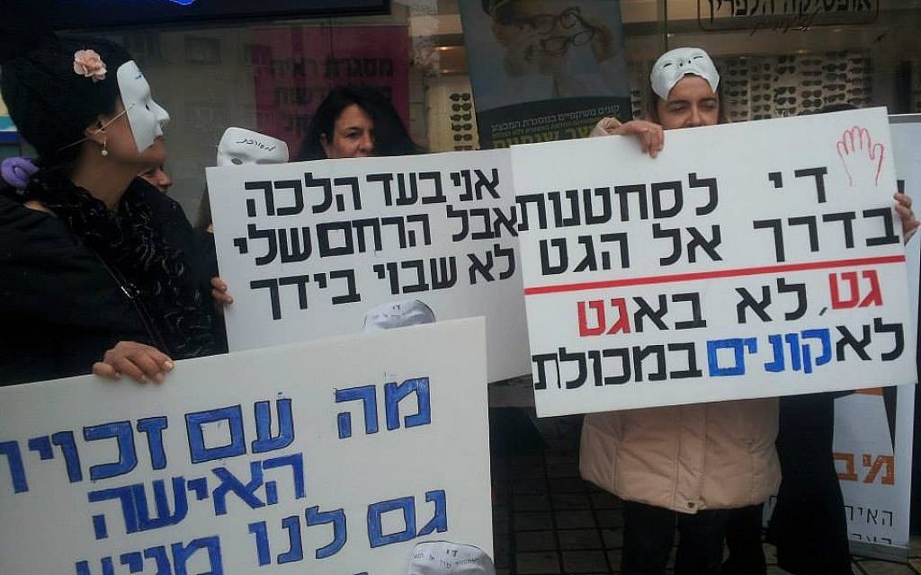 Demonstrators holding signs on Agunah Day, in protest of women trapped in marriages. The sign on the right reads 'Enough extortion on the road to a get,' referring to a Jewish divorce document. (courtesy of Mavoi Satum)
