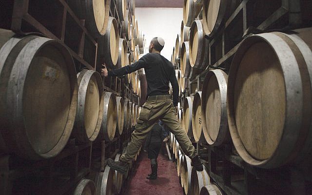 Israeli workers inspects barrels in a winery in the West Bank settlement of Psagot. Feb. 11, 2014. (AP Photo/Dan Balilty)