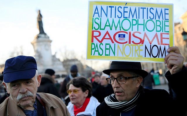 FILE PHOTO: People attend a national gathering to protest anti-Semitism and the rise of anti-Semitic attacks in the Place de la Republique in Paris, France, February 19, 2019. The writing on the sign reads: "Antisemitism, islamophobia, racism - not in our name".  REUTERS/Gonzalo Fuentes/File Photo