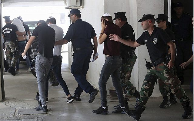 Israeli then-suspects of rape cover their faces with their shirts as they arrive at the Famagusta courthouse in Paralamni, Cyprus, July 26, 2019. They were later exonerated of the rape when their accuser acknowledged she had fabricated her story. (AP Photo/Petros Karadjias) Israeli then-suspects of rape cover their faces with their shirts as they arrive at the Famagusta courthouse in Paralamni, Cyprus, July 26, 2019. They were later exonerated of the rape when their accuser acknowledged she had fabricated her story. (AP Photo/Petros Karadjias)