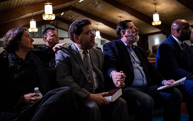 Pittsburgh Mayor Bill Peduto, right, holds hands with Rabbi Jonathan Perlman, who survived the shooting, at Rodman Street Missionary Baptist Church during service for the victims who were killed at the mass shooting at the Tree of Life Synagogue, on October 31, 2018, in Pittsburgh, PA. (Photo by Salwan Georges/The Washington Post via Getty Images)