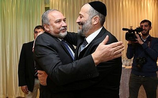 Aryeh Deri (left), leader of the ultra-Orthodox Shas party, seen with head of the Yisrael Beytenu political party Avigdor Liberman at the “Sheva Brachot” of Deri’s daughter. December 23, 2015. (Yaacov Cohen/FLASH90)
